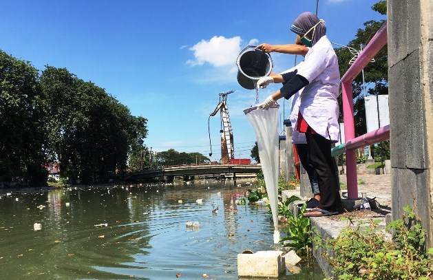 Gambar yang mewakili dampak pencemaran logam berat pada lingkungan, termasuk kerusakan tanah dan air.