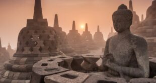 Candi Borobudur di tengah pemandangan hijau, dengan stupa-stupa Buddha terlihat jelas