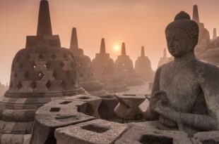 Candi Borobudur di tengah pemandangan hijau, dengan stupa-stupa Buddha terlihat jelas