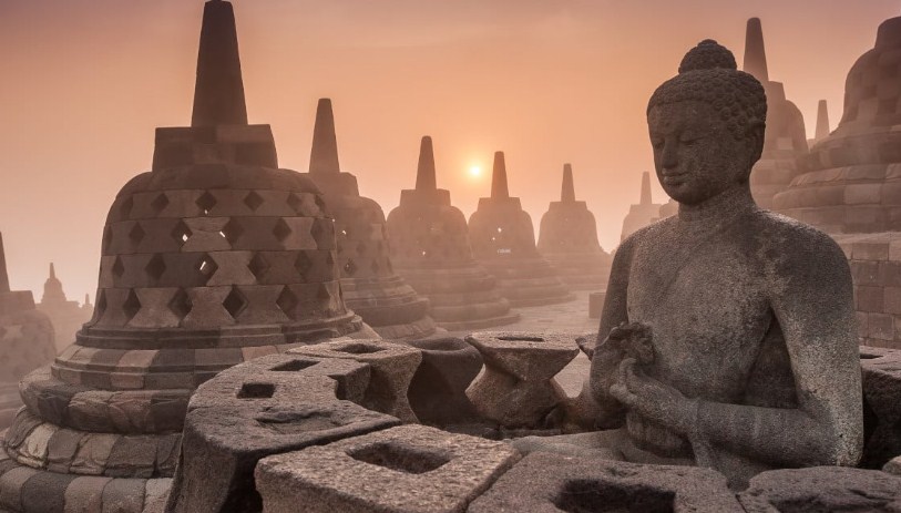 Candi Borobudur di tengah pemandangan hijau, dengan stupa-stupa Buddha terlihat jelas